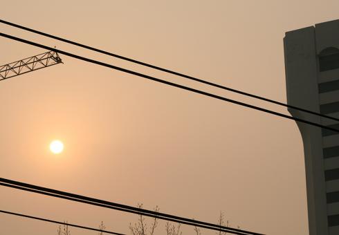 Beijing, China - Sun and smog in a hazy orange-brown sky.