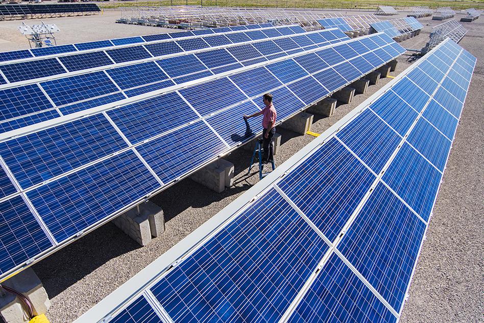 Solar engineer Joshua Stein works on one of several photovoltaic systems being evaluated for industry partners at Sandia National Laboratories in the U.S. Regional Test Centers program. Sandia won a three-year renewal of a Department of Energy contract to manage the RTCs, a network of five sites across the country where industry can assess the performance, reliability and economic viability of solar photovoltaic (PV) technologies. (Photo by Randy Montoya)